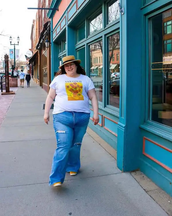 Oversized Graphic Shirt + Flared Jeans + Sneakers + English Hat