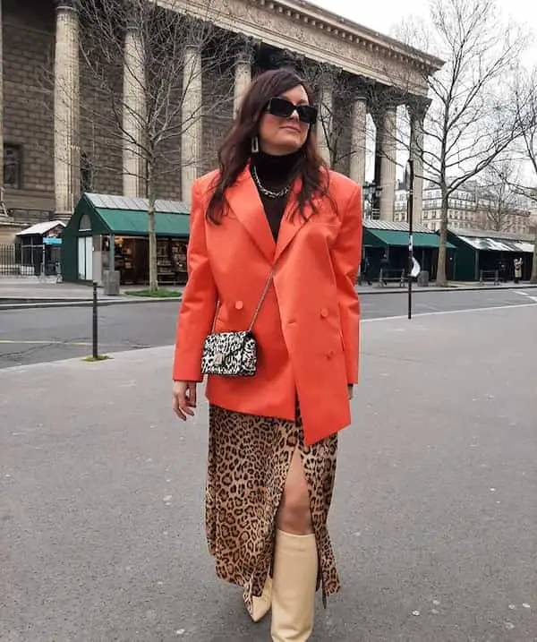 Black Top + Oversized Orange Blazer + Animal Skin Skirt + Knee-Length Boots + Cross Bag + Sunglasses
