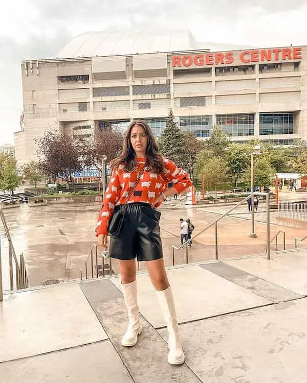 Orange Shirt with Leather Shorts + Knee-High Boots + Cross Shoulder Handbag