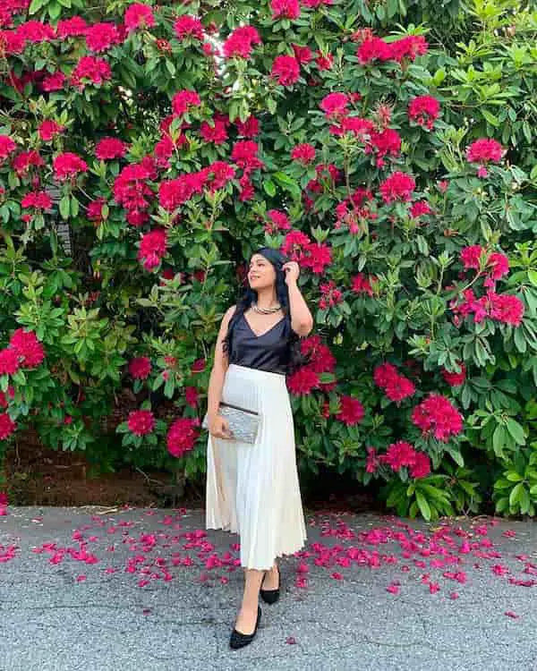 White Midi Pleated Skirt with Black Blouse + Black Loafers + Silver Clutch Purse