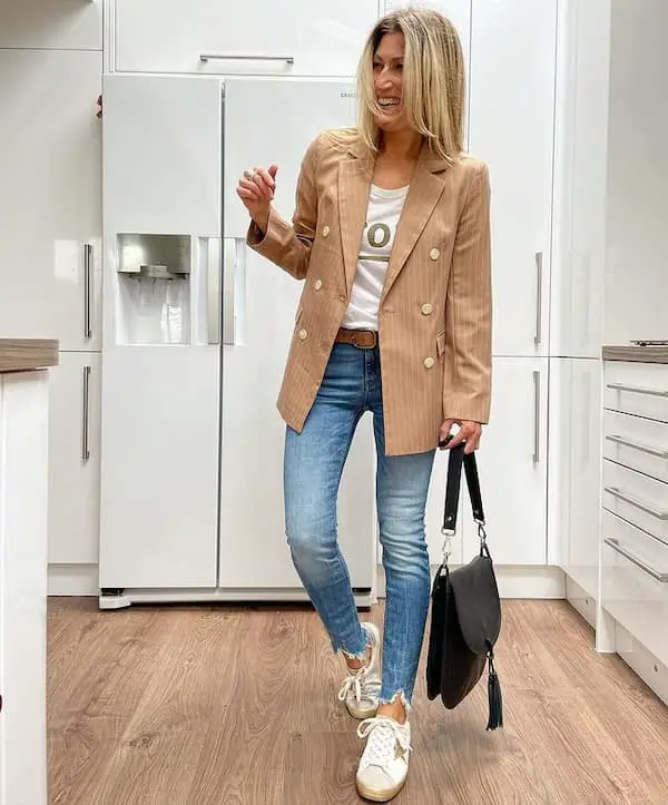 Blue Skinny Jeans and Tan  Oversized Blazer with White Graphic Shirt + Sneakers + Handbag
